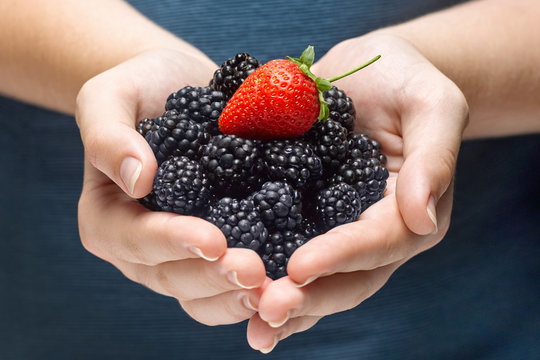closeup of woman hands holding berries at home.