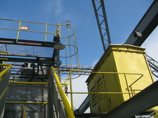 dangerous workplace in height, yellow steel cabin, steel working platforms, traverses, steel beams, leaders and scaffolds