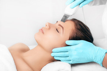 Beautiful woman receiving ultrasound cavitation facial peeling. Cosmetology and facial skin care