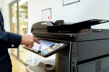 Bussiness man Hand press button on panel of printer, printer scanner laser office copy machine supplies start concept.