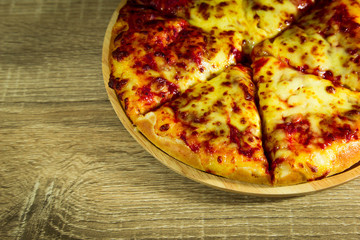 Pizza Margarita with mozzarella cheese on a wooden table.