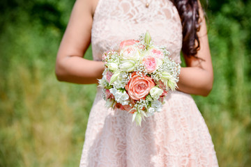 Wedding bouquet - Beautiful flowers in bride's hands in a white dress.