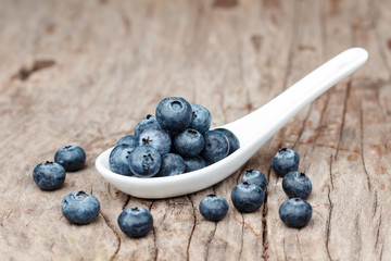Blueberries in white spoon on wooden table, Healthy eating and nutrition concept