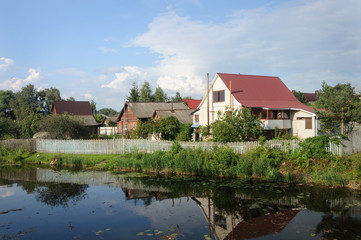 Fototapeta na wymiar Houses on riverbank in small Russian town