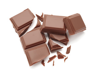 Delicious milk chocolate pieces on white background
