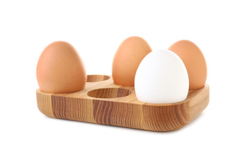 Wooden holder with chicken eggs on white background