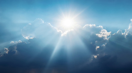 Panoramic view of clouds and sun with beautiful rays against the sky.