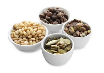 Bowls with different nuts on white background