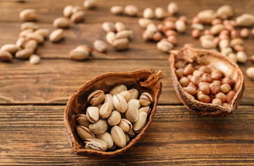 Cocoa pod with different nuts on wooden background