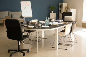 Conference hall with big table prepared for business meeting