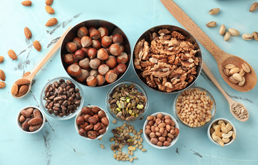 Bowls and spoons with different nuts on table
