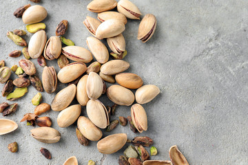 Tasty pistachio nuts on grey background