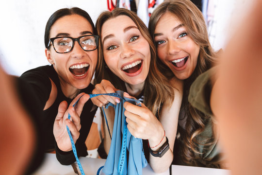 Three positive young women clothes designers - Powered by Adobe