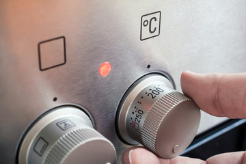 Male Hand Using Oven Controls To Set Temperature