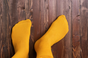 Yellow mans socks on a wooden background, top view