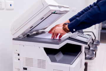 Bussiness man Hand press button on panel of printer, printer scanner laser office copy machine supplies start concept.