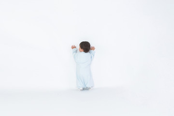 Infant child baby girl kid toddler in diaper make first steps isolated on a white background