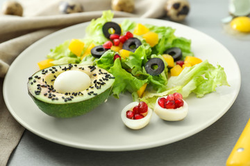 Plate with tasty avocado salad on table