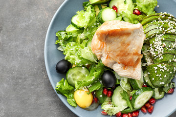 Plate with tasty avocado salad on table, closeup