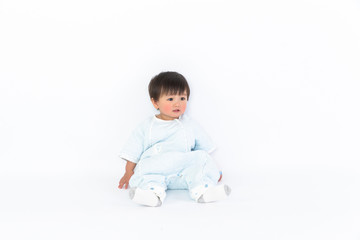 beautiful little baby sits on the floor isolated on white background