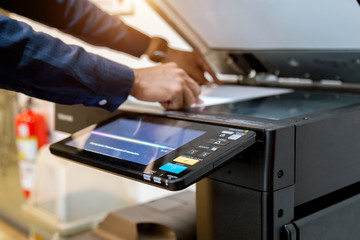 Bussiness man Hand press button on panel of printer, printer scanner laser office copy machine supplies start concept.