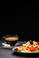 Photo of cup of coffee with Belgian wafers with strawberries, raspberries