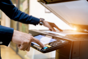 Bussiness man Hand press button on panel of printer, printer scanner laser office copy machine...