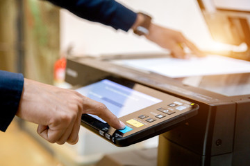 Bussiness man Hand press button on panel of printer, printer scanner laser office copy machine supplies start concept.
