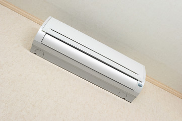 Air conditioner of white color on wall background, split-system in apartment with textured...