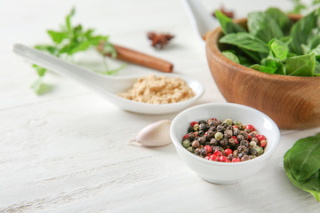 Composition with different spices and herbs on white wooden background