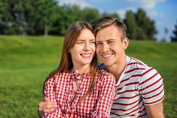 Fototapeta premium Young couple relaxing in park on sunny day
