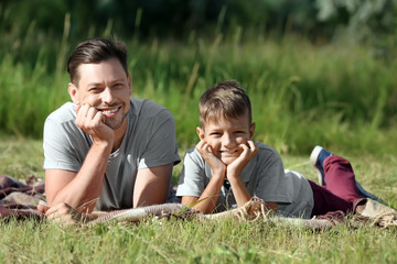 Man with his little son resting in park