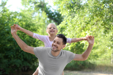 Happy man with his little daughter in park