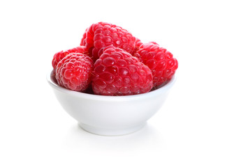 Bowl with ripe raspberries on white background