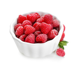 Bowl with ripe raspberries on white background
