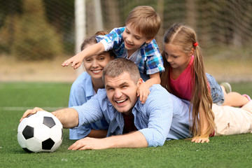 Happy family with soccer ball outdoors