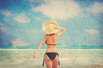 Young redhead girl in black bikini and with hat on Balos beach, west Crete, Greece. Summertime season vacation, July. Image in retro style