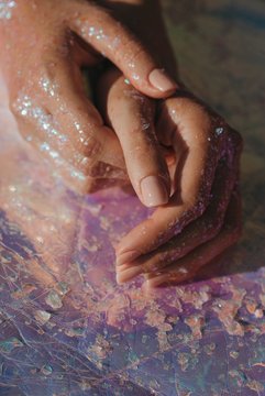 Human hands covered in glitter