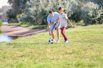 Father with son playing football outdoors