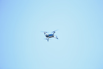 blue quadrupter with propellers flies in the sky and photographs landscapes