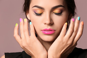 Beautiful young woman with professional manicure on color background, closeup