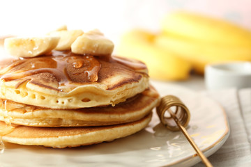 Fototapeta na wymiar Tasty pancakes with sliced banana and honey on plate, closeup