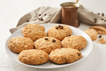 Plate with sweet cookies and jezve of aromatic coffee on table