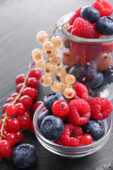 Bowl with different ripe berries on table