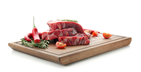 Wooden board with raw meat and fresh spices on white background