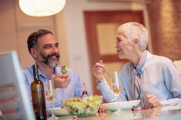 Mature couple having lunch together at home