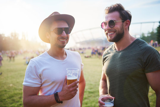 Two young male friends with glasses of beer at Holi Festival