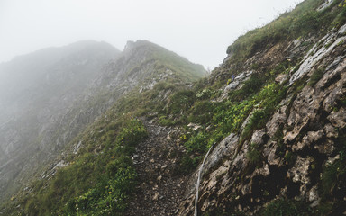 scary hiking path covered fog on the ridge of a mountain in the swiss alps, brienzer rothorn switzerland