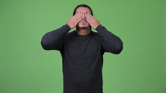 Handsome man covering eyes as three wise monkeys concept