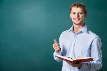 Young male teacher on blackboard